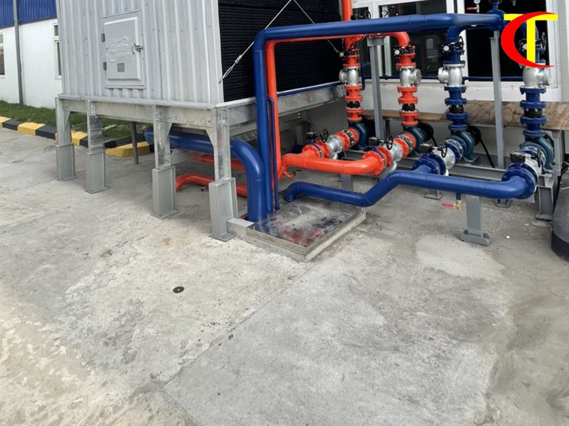 So sánh Chiller và VRV: nên chọn hệ điều hòa trung tâm nào? Tháp giải nhiệt nước và đường ống đặt cạnh tường nhà xưởng